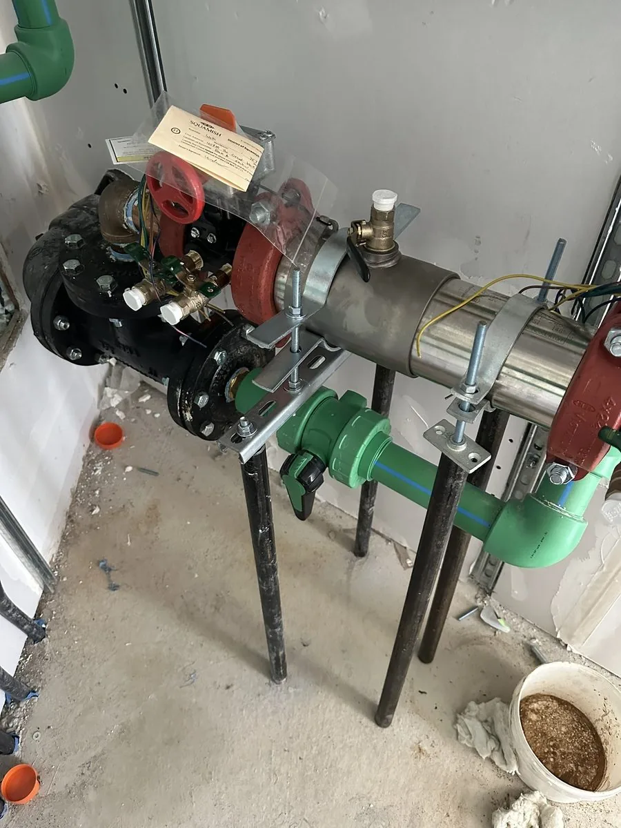 Water service line and backflow connection in a service pit