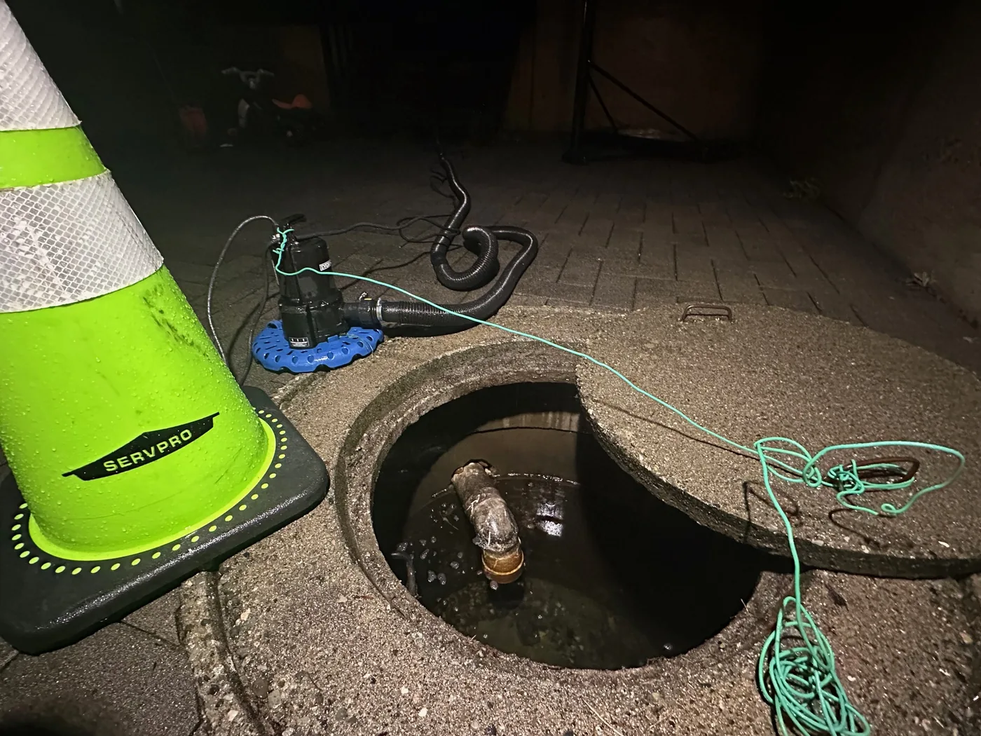 After-hours emergency dewatering with a submersible pump at a flooded manhole