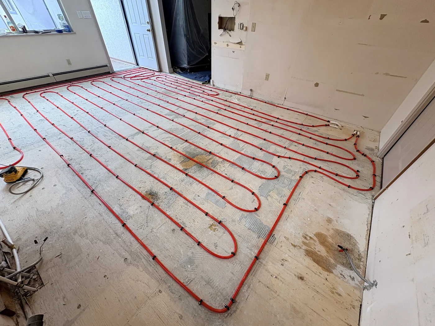 Radiant floor heating loops secured across a subfloor before the pour